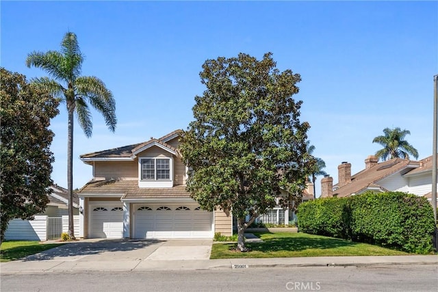 view of front of house with concrete driveway, a tiled roof, a front yard, and a garage