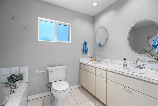 full bathroom with a sink, baseboards, toilet, and double vanity