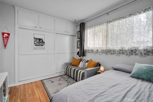 bedroom featuring baseboards, a closet, and wood finished floors