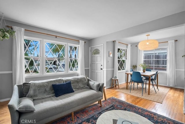living area featuring baseboards and light wood finished floors