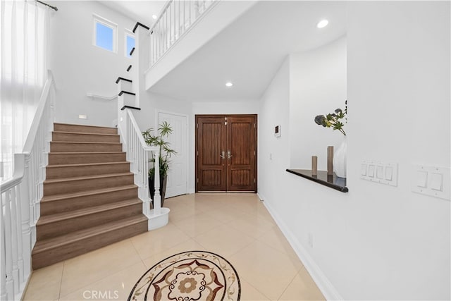 entryway with stairs, recessed lighting, baseboards, and light tile patterned floors