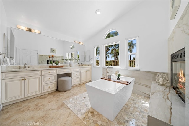 full bath featuring a freestanding bath, plenty of natural light, and double vanity