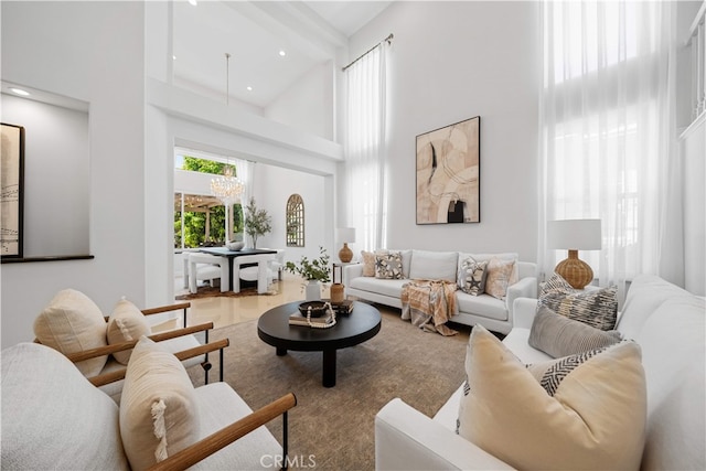 living area with recessed lighting, a high ceiling, and wood finished floors