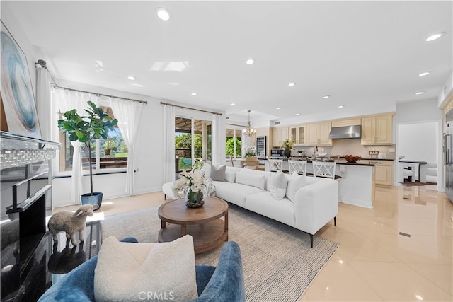 living area featuring light tile patterned floors, recessed lighting, and a notable chandelier