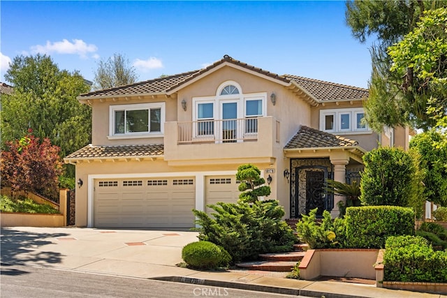 view of front of house featuring an attached garage, stucco siding, driveway, and a tile roof