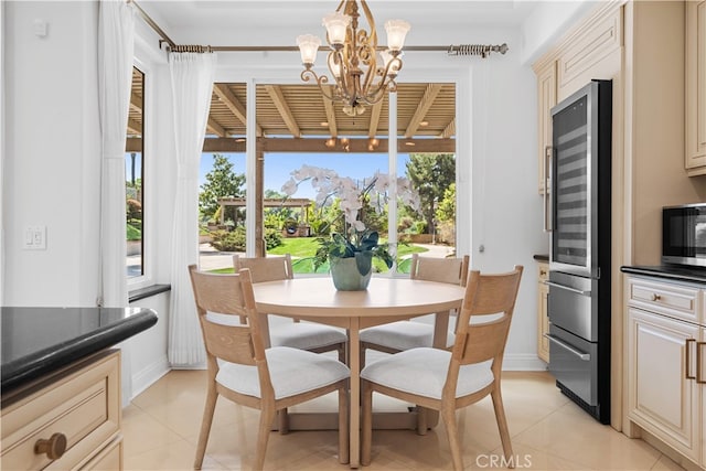 dining area with light tile patterned floors, baseboards, beverage cooler, and a chandelier
