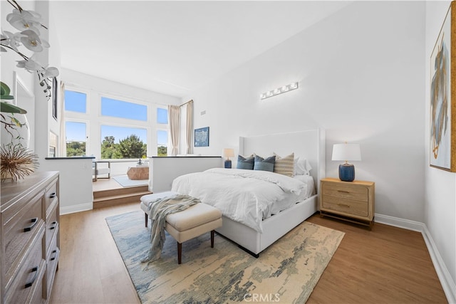 bedroom with baseboards and wood finished floors