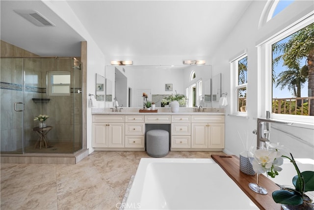 bathroom with a sink, a shower stall, double vanity, and visible vents