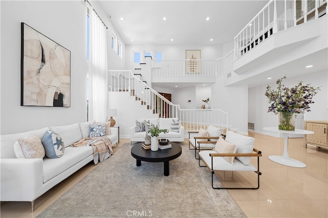 tiled living area featuring stairs, recessed lighting, and a towering ceiling