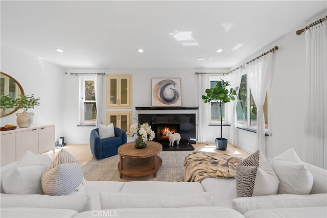 living room with recessed lighting and a lit fireplace