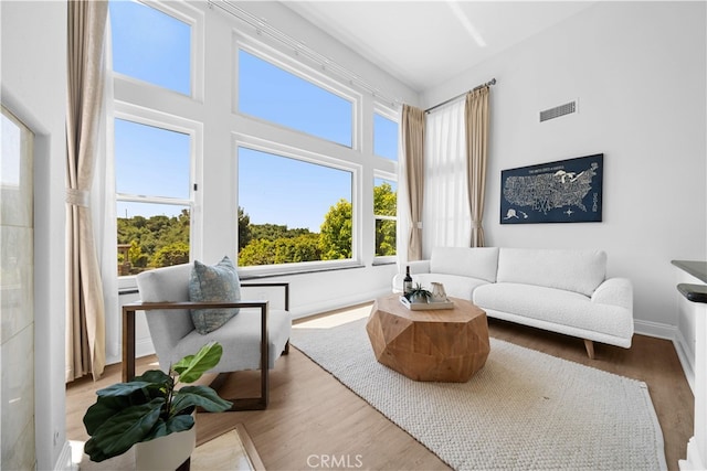 living area featuring baseboards, wood finished floors, and visible vents