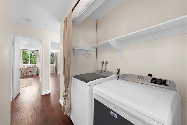 clothes washing area featuring independent washer and dryer, laundry area, dark wood-style floors, and baseboards