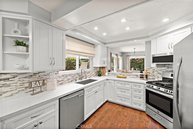 kitchen featuring white cabinets, appliances with stainless steel finishes, plenty of natural light, and a sink