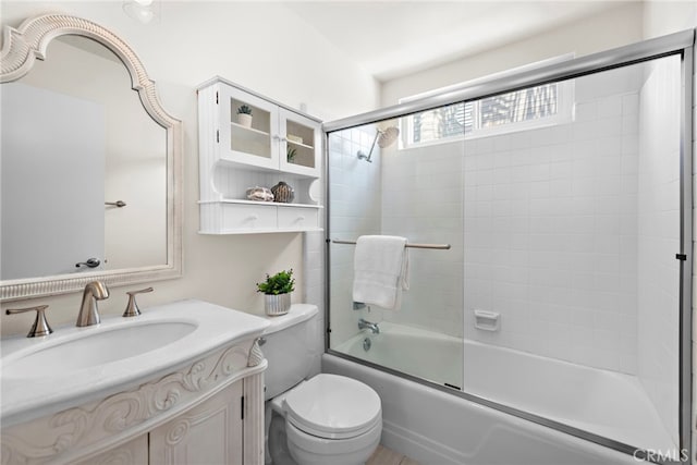 bathroom with vanity, combined bath / shower with glass door, and toilet
