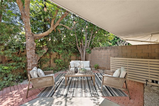view of patio featuring fence, outdoor lounge area, and a deck