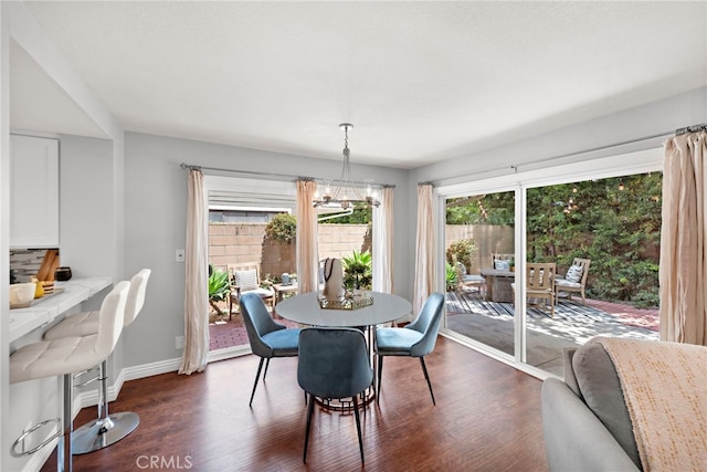 dining room with an inviting chandelier, baseboards, and dark wood-style flooring