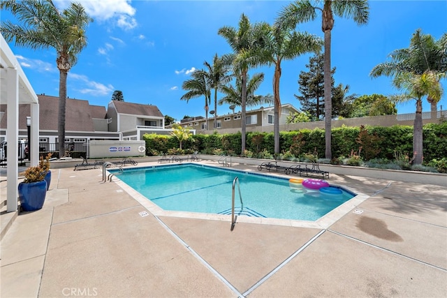 community pool featuring fence and a patio area