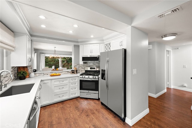 kitchen with visible vents, appliances with stainless steel finishes, a sink, ornamental molding, and white cabinetry