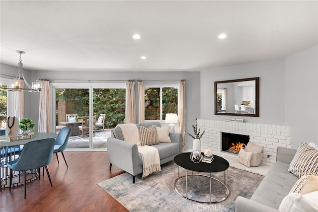 living area featuring a healthy amount of sunlight, recessed lighting, wood finished floors, and a notable chandelier