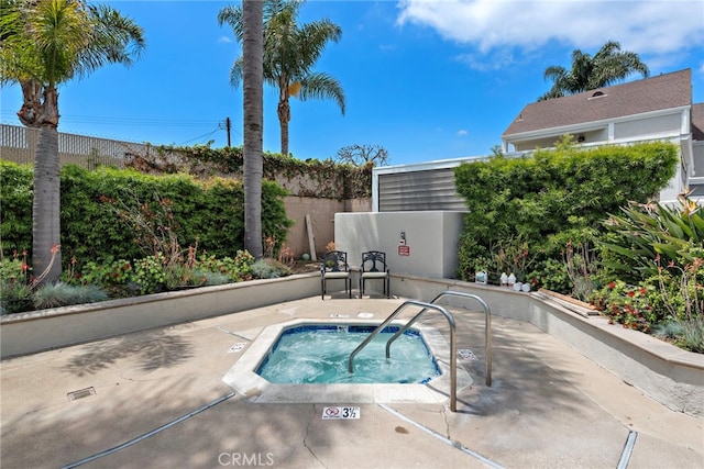 view of pool featuring a community hot tub and fence