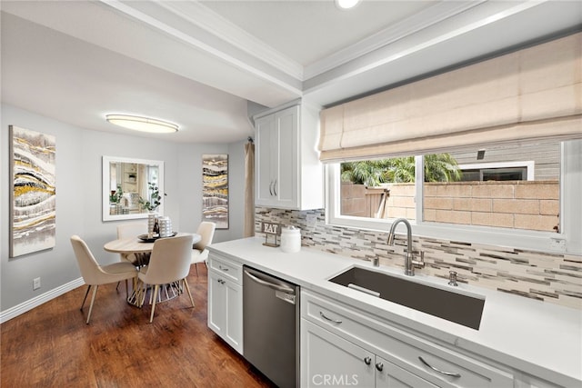 kitchen featuring stainless steel dishwasher, a sink, crown molding, and tasteful backsplash