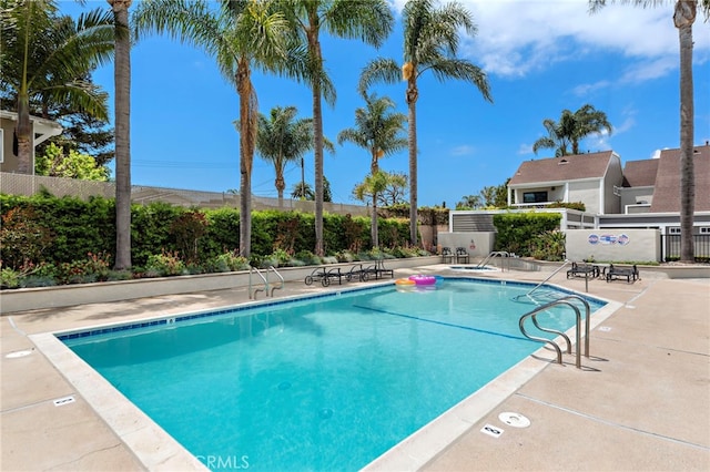 community pool featuring a patio and fence