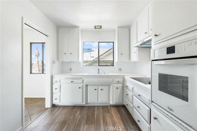 kitchen featuring dark wood-type flooring, white cabinetry, black electric stovetop, and oven