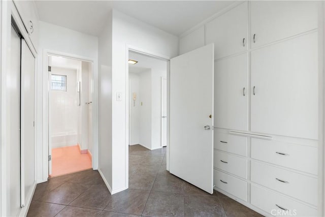 hallway with dark tile patterned flooring