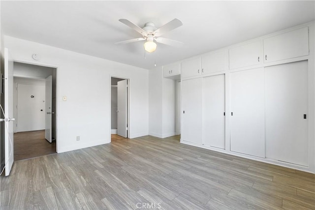 unfurnished bedroom with baseboards, ceiling fan, and light wood-style floors