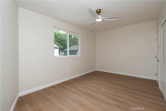 unfurnished room with baseboards, light wood-style flooring, and ceiling fan