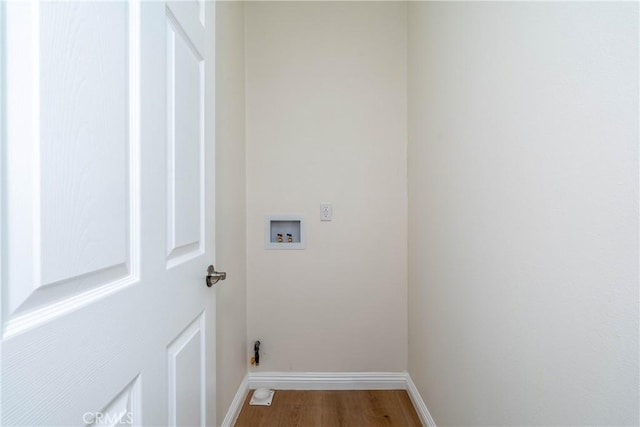 clothes washing area featuring baseboards, laundry area, wood finished floors, and hookup for a washing machine