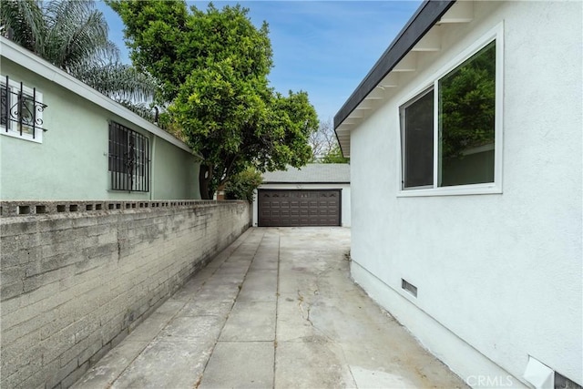 view of side of property with crawl space, a garage, and stucco siding
