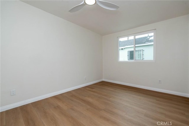 spare room with light wood-style floors, baseboards, and ceiling fan