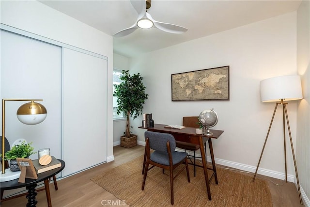 office space with a ceiling fan, baseboards, and light wood-type flooring