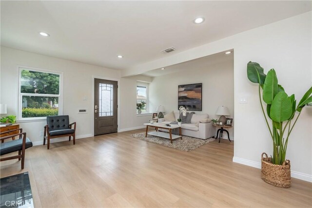 living room with recessed lighting, light wood-style flooring, and visible vents