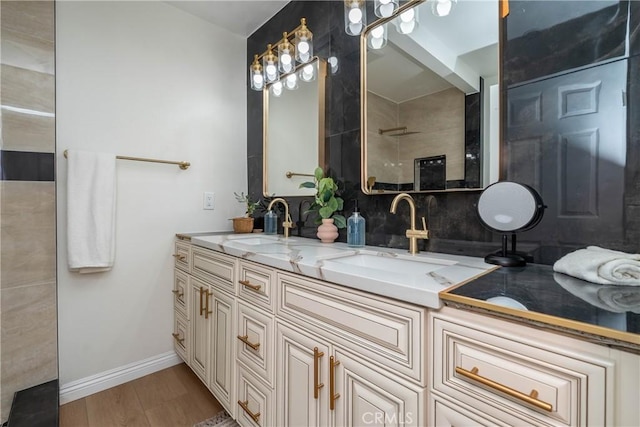 full bathroom featuring double vanity, a sink, decorative backsplash, and baseboards