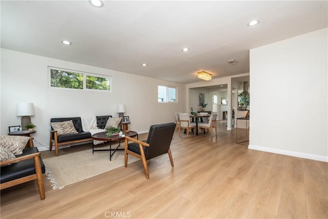 living room featuring light wood-style floors, baseboards, and recessed lighting