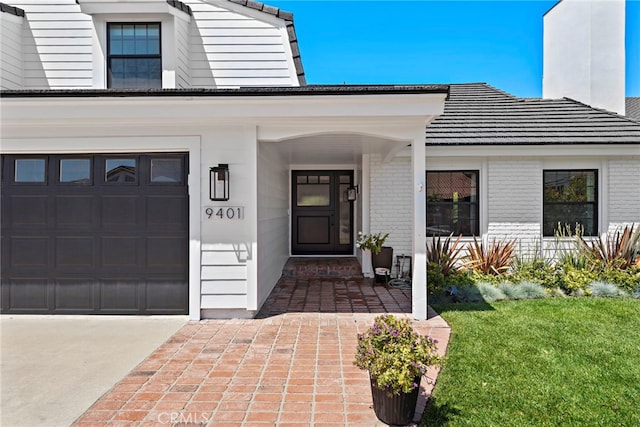 9401 Gateshead Dr, Huntington Beach, CA 92646 - view of exterior entry featuring brick siding, an attached garage, a yard, and covered porch