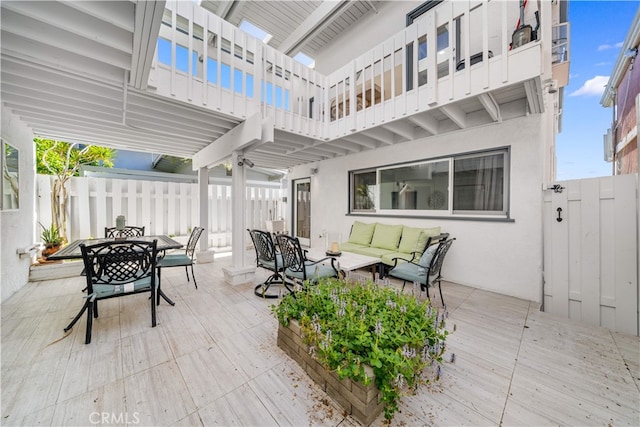 view of patio / terrace featuring an outdoor hangout area, outdoor dining area, fence, a balcony, and a deck