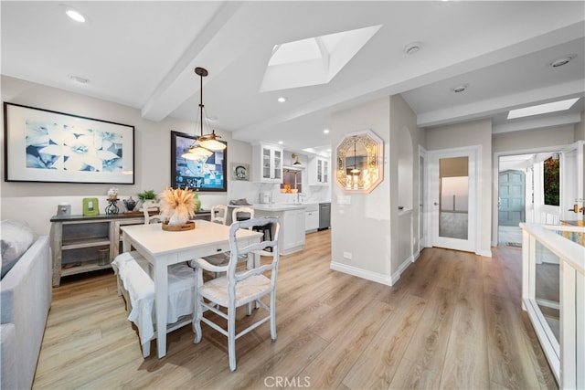 dining area featuring a skylight, light wood-style floors, baseboards, beamed ceiling, and recessed lighting
