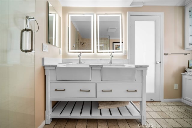 bathroom featuring double vanity, an enclosed shower, and baseboards