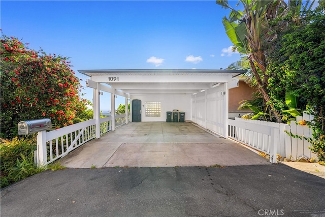 view of front of home featuring asphalt driveway, a carport, and fence