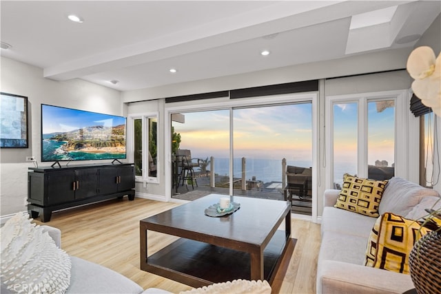 living area featuring light wood-style flooring, recessed lighting, and a water view