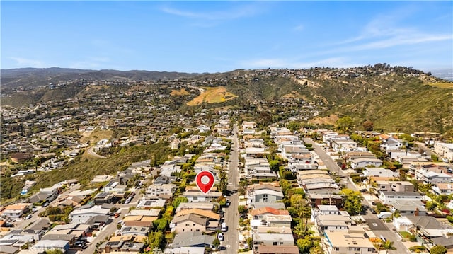 aerial view of property's location featuring a mountainous background and nearby suburban area