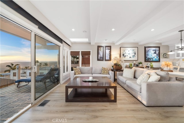 living area featuring beam ceiling, light wood-type flooring, and recessed lighting