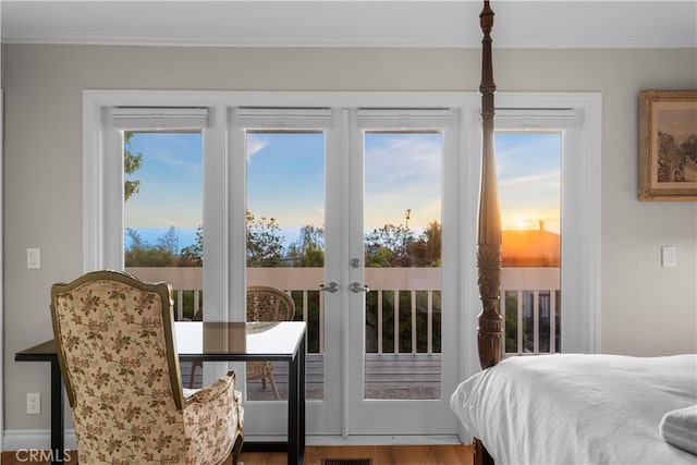 bedroom with access to outside, french doors, crown molding, and wood finished floors