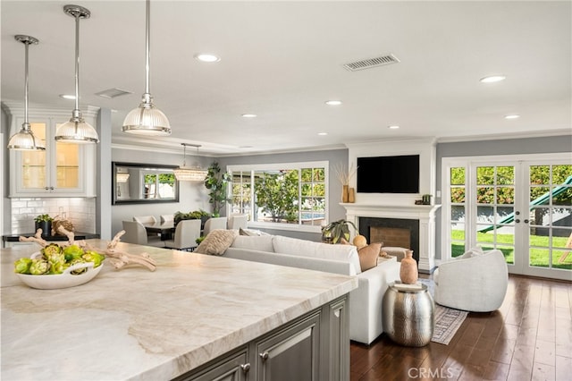kitchen featuring visible vents, crown molding, dark wood-style flooring, a fireplace, and recessed lighting
