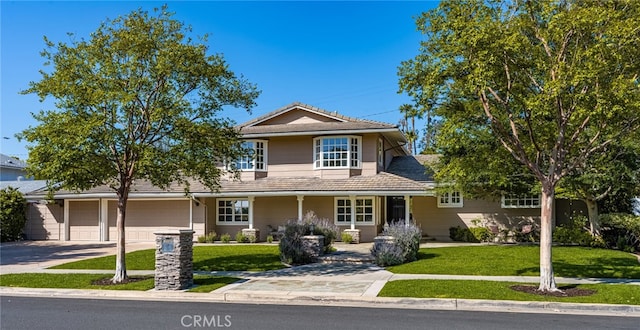 traditional home with concrete driveway and a front lawn