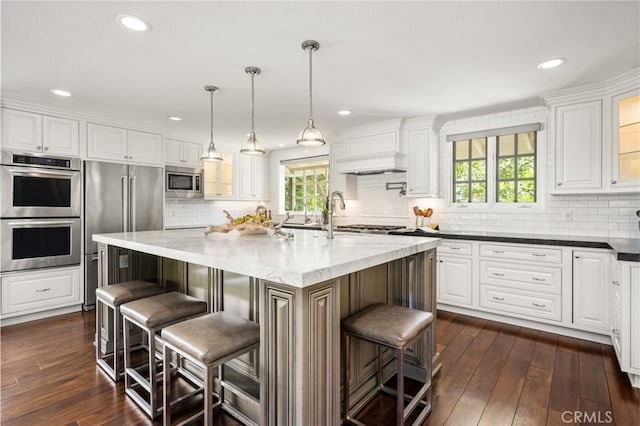 kitchen featuring white cabinets, stainless steel appliances, glass insert cabinets, and a wealth of natural light