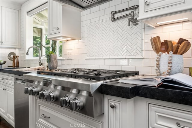 kitchen featuring backsplash, white cabinets, a sink, and stainless steel gas stovetop